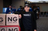 person in Northrop Grumman shirt and hat smiling