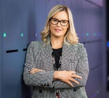 Photo of woman glasses with folded arms smiling.