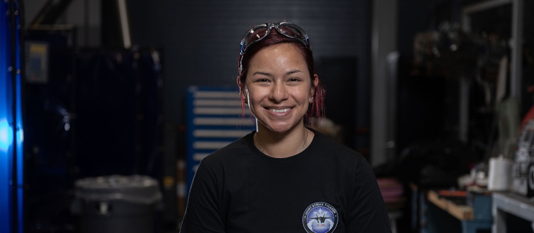 A woman smiling in a mechanical shop