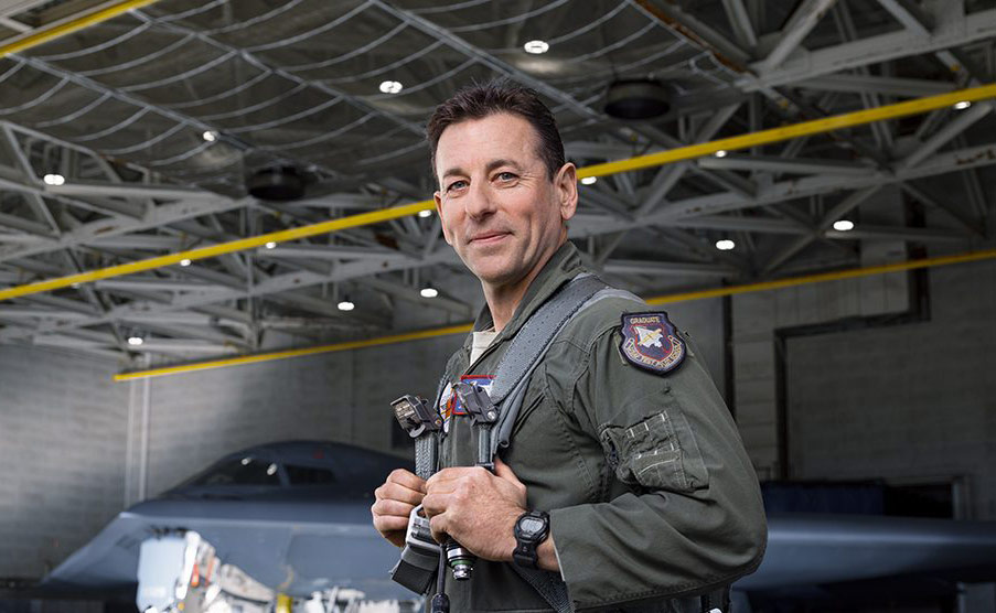 man in flight suit standing in air hanger