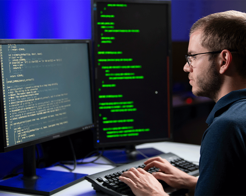 man sitting at a computer looking at code