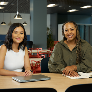 two women sitting next to each other smiling