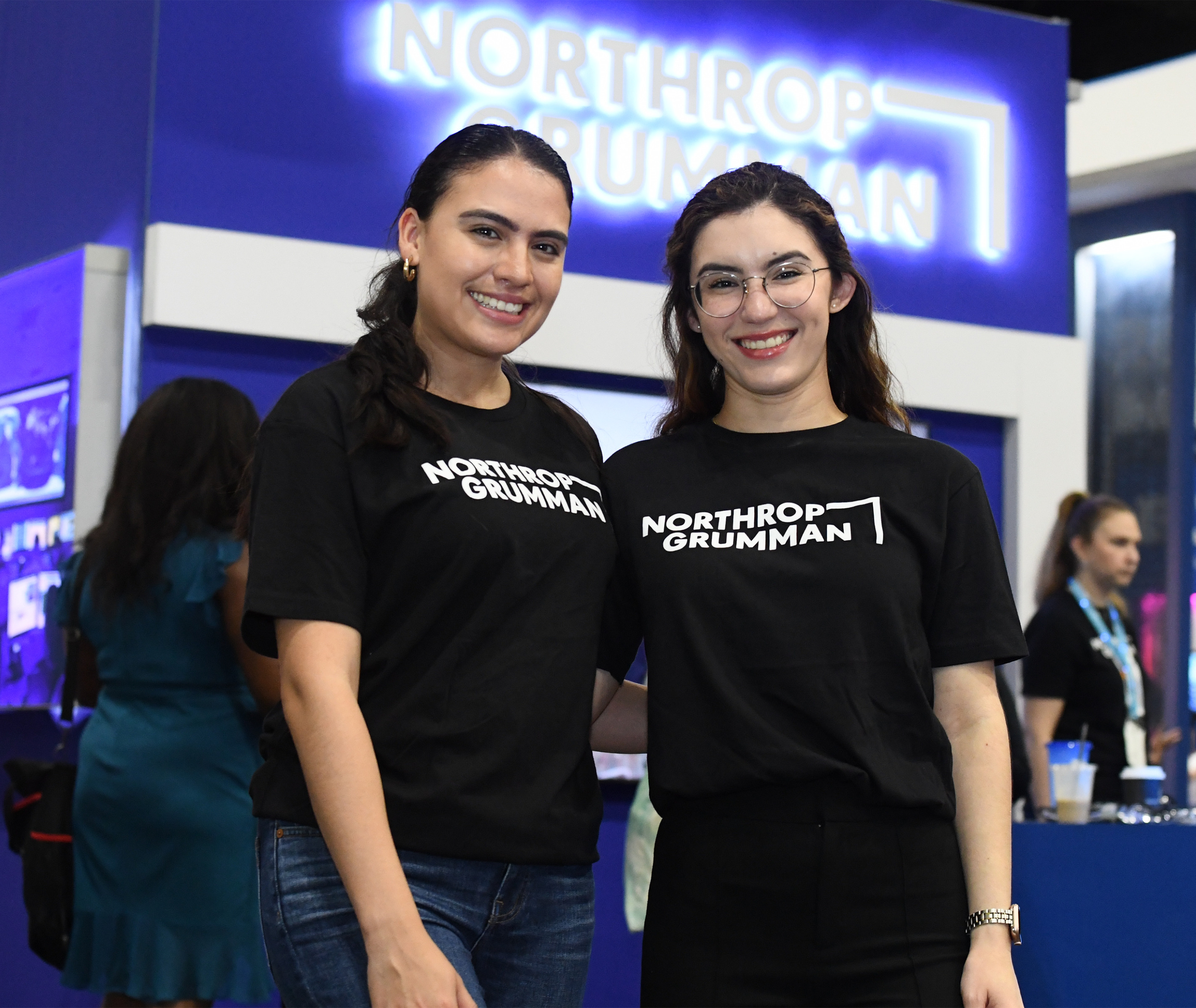 two women in Northrop Grumman shirts at a conference