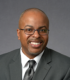 Portrait of black man wearing glasses smiling at camera