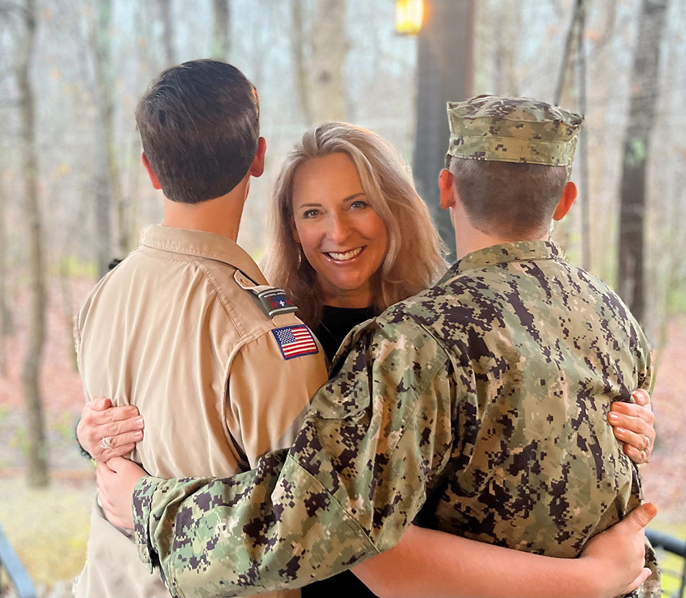 women hugging military solider and eagle scout boy