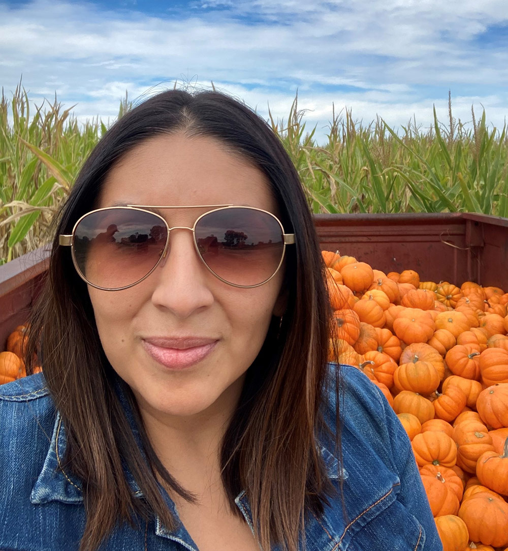 woman wearing sunglasses in pumpkin patch