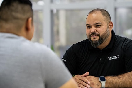 two people sitting at a table talking