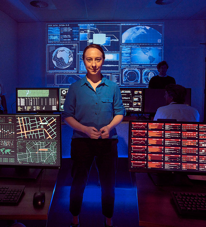 female in blue coat standing in situation room