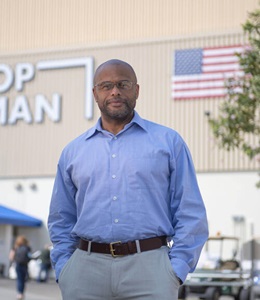 Michael Carter in front of Northrop Grumman building with American flag