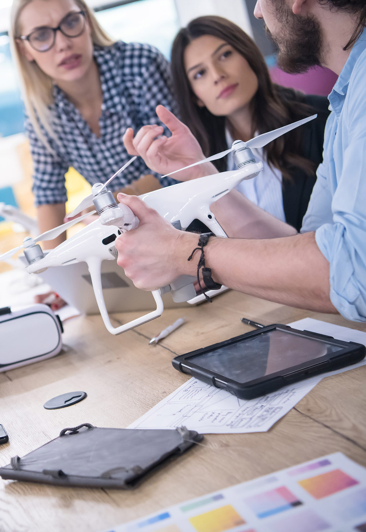 students and teacher with a drone on a desk