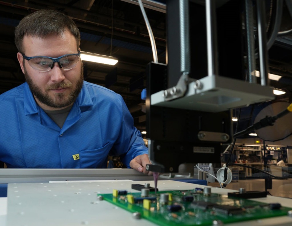 man working at manufacturing equipment used for fluid application processes