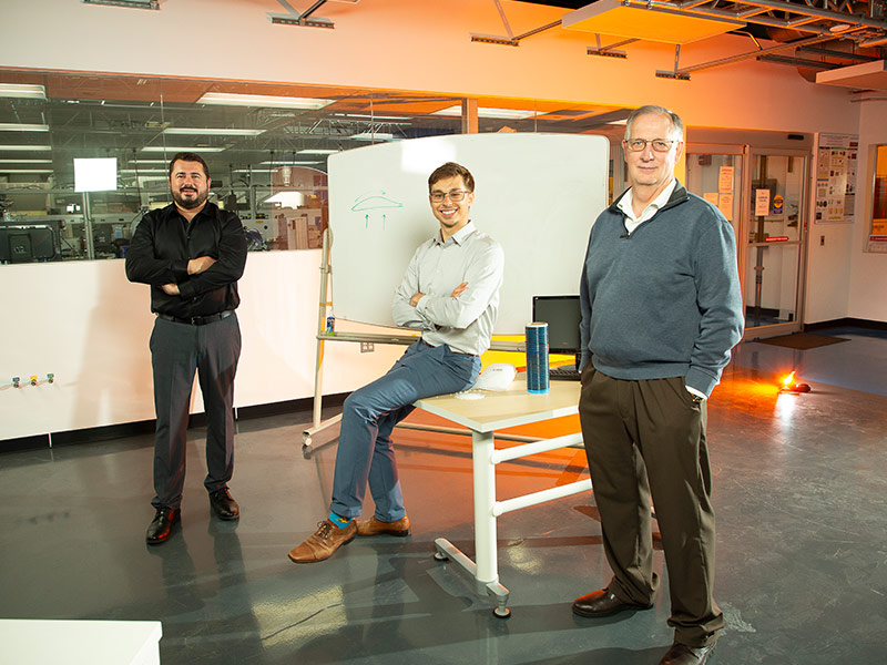 three men standing in an office
