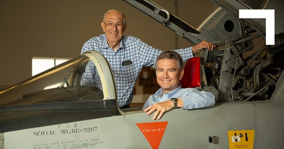 two men and fighter jet