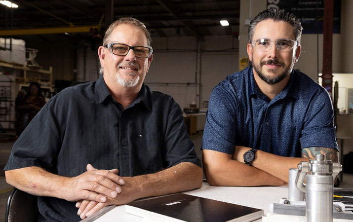 two smiling men wearing protective eyewear