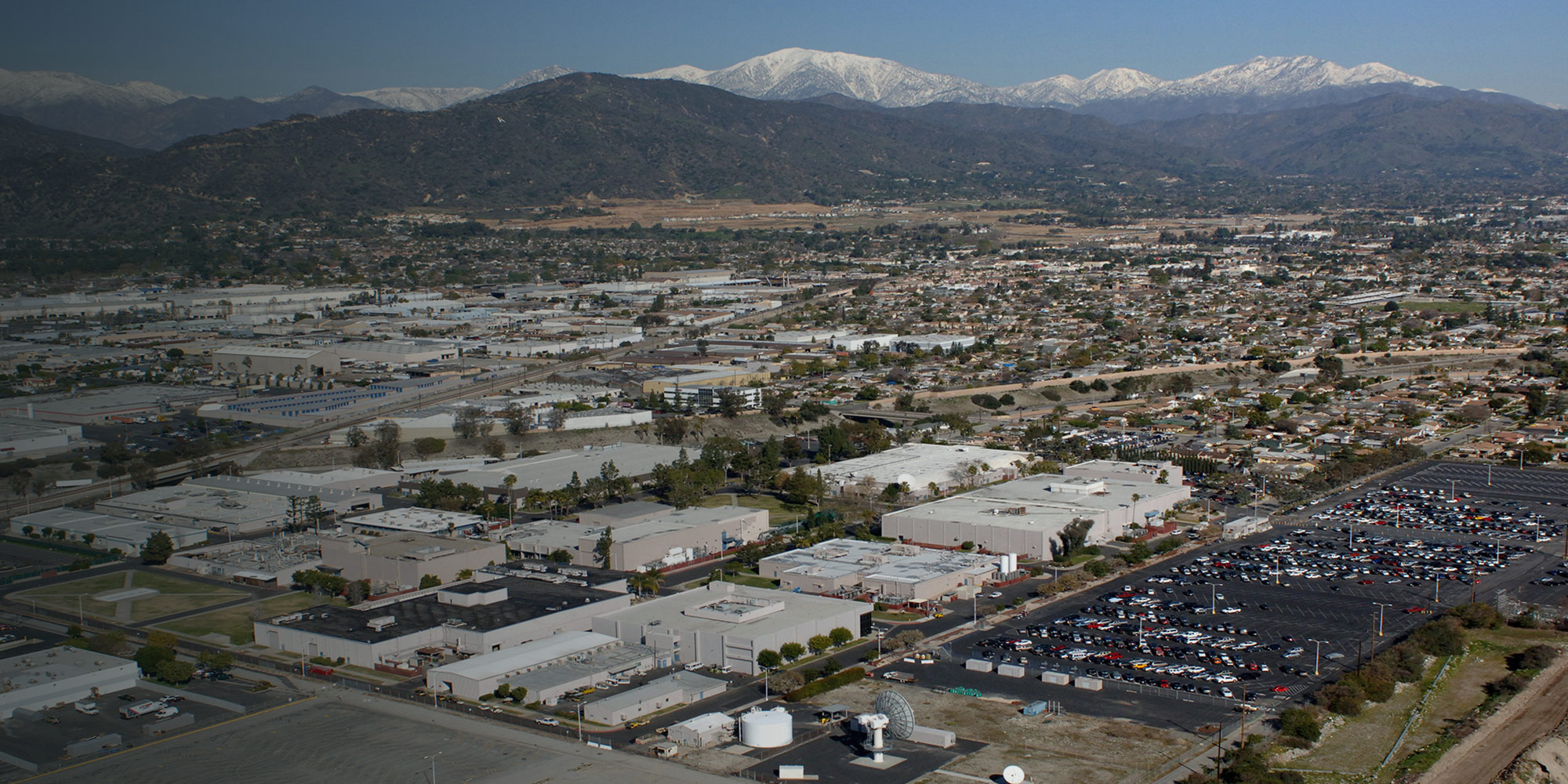 Aerial view of the Northrop Grumman Azusa facility with snow-capped mountains in background