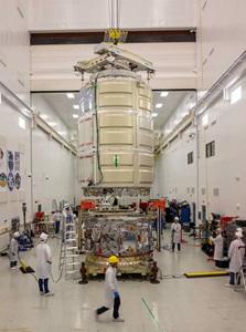 Engineers working on spacecraft in building