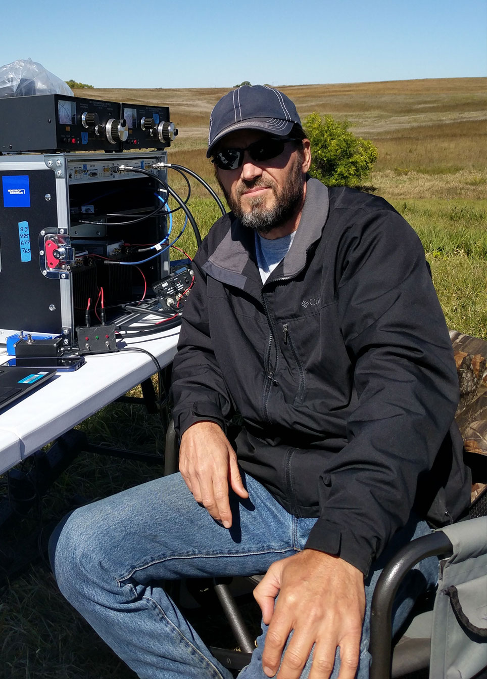 Man sitting in field with engineering equipment