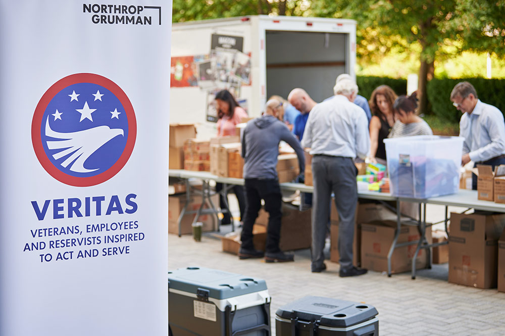 employees packing backpacks with items supplied by Operation Homefront to be delivered to military students