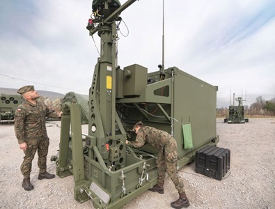 two soldiers working on military equipment.