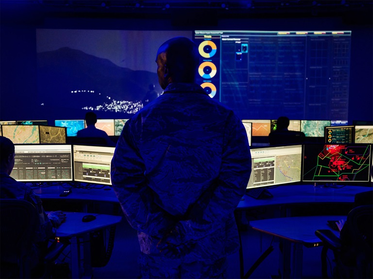Silhouette of military member in control center
