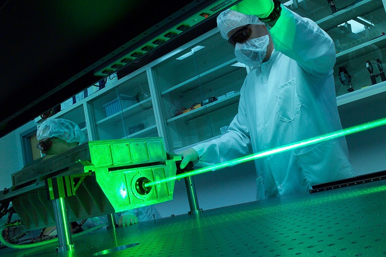 Man wearing protective eyewear and clean suit working on green laser