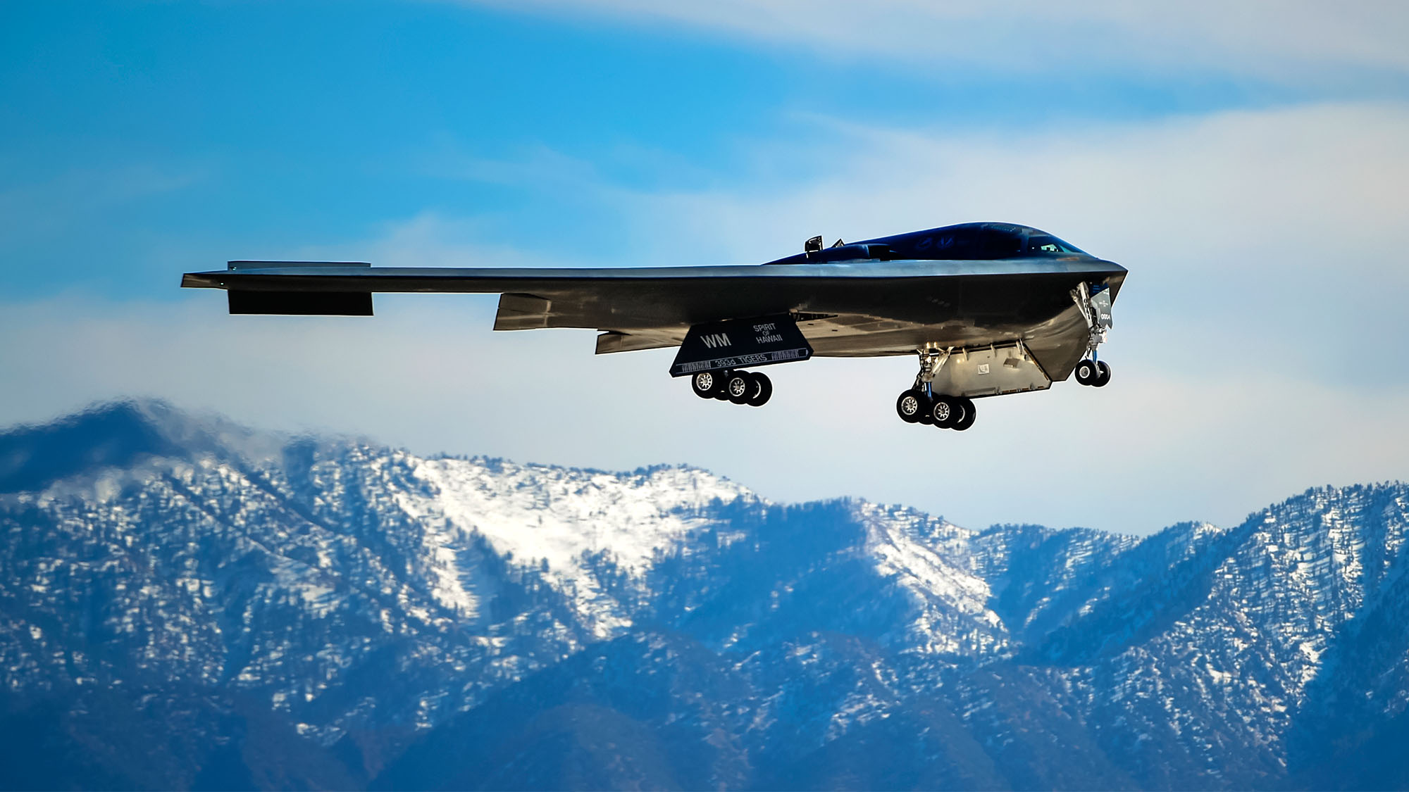 B-2 Spirit Stealth Bomber 160210pmar072013 B-2 Spirit Stealth Bomber flying with snow capped mountains in background