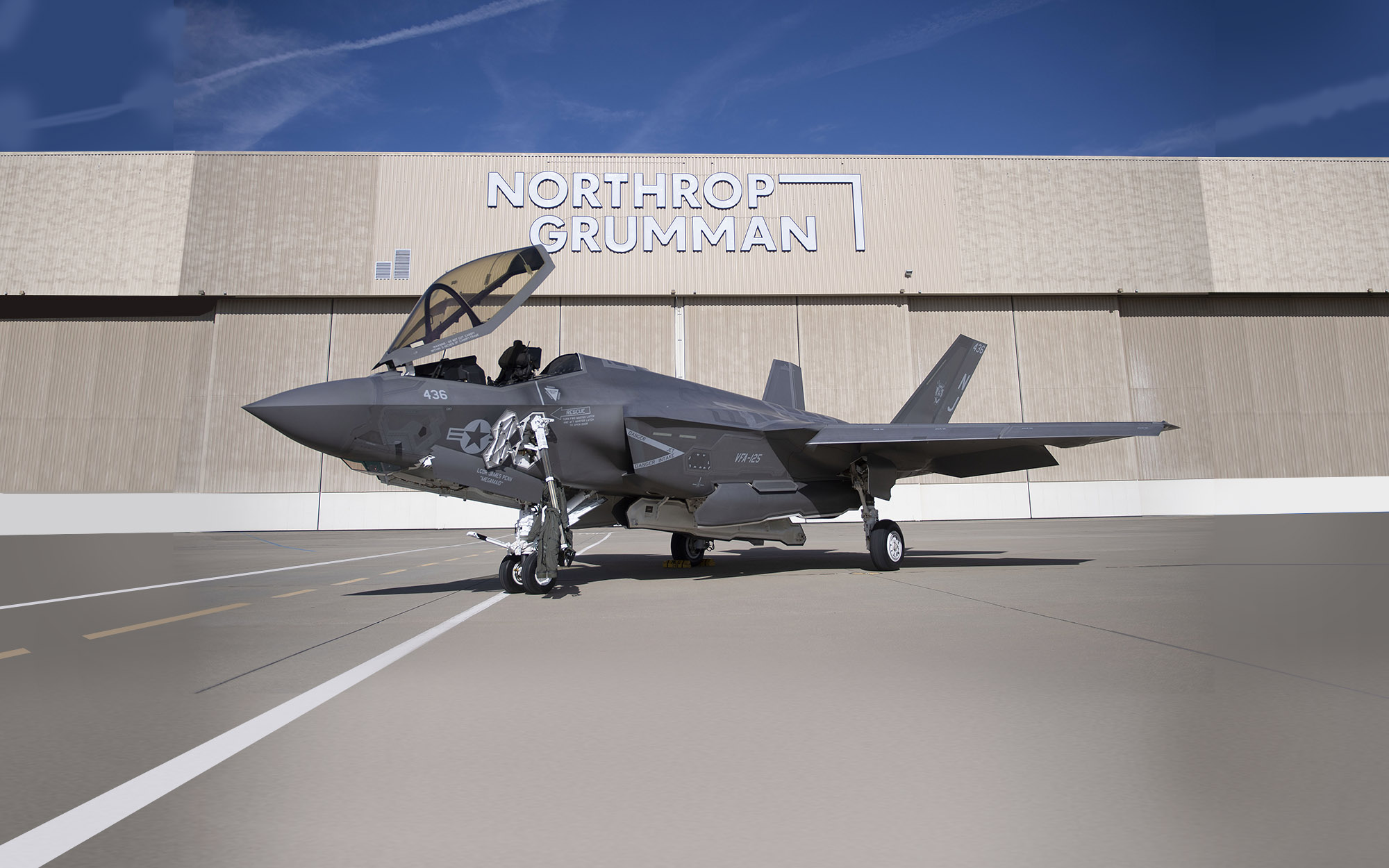 fighter jet on tarmac in front of hangar