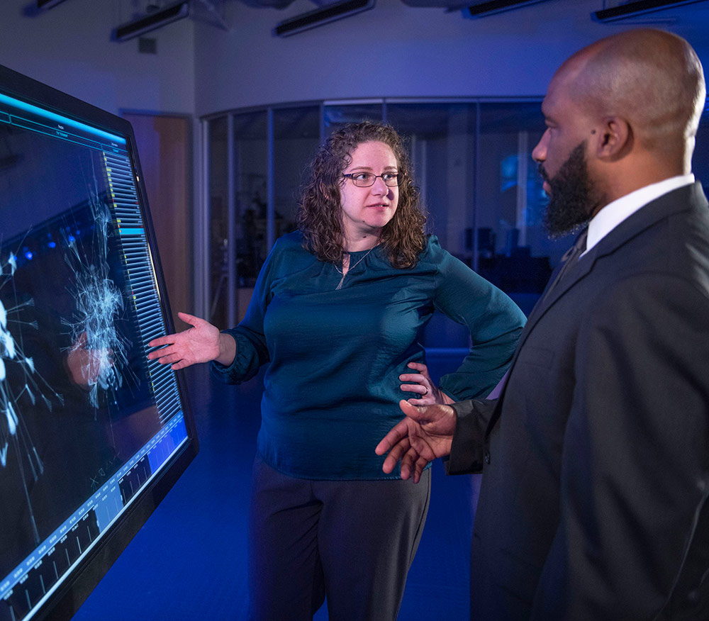 employee presenting to man information on monitor 