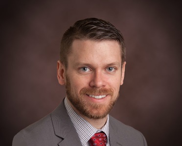 headshot of smiling white male with red hair and beard