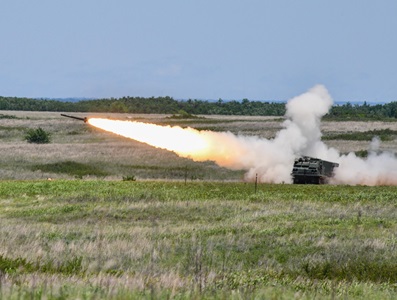 tank launching tactical missile in green field