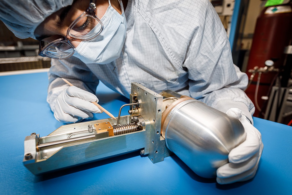 female in clean suit working on cryocooler