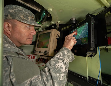 military man pointing to screen in vehicle