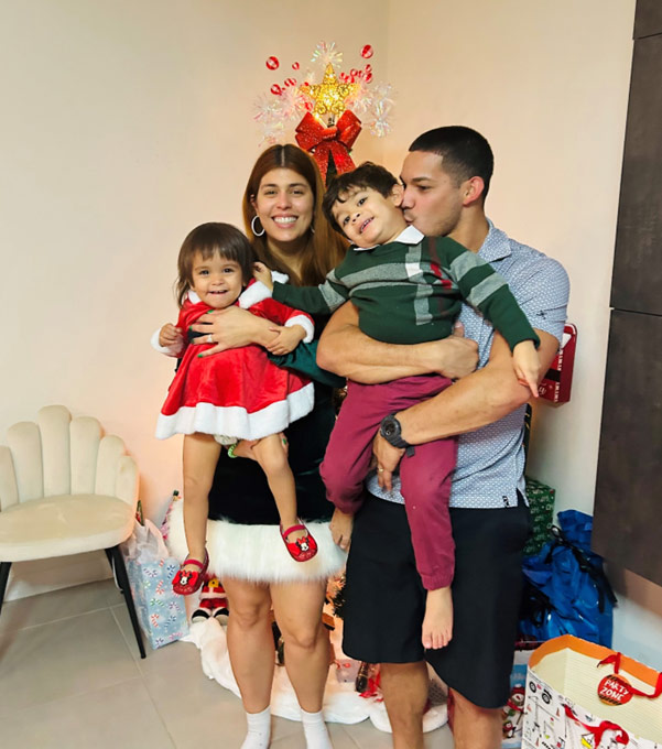 Sabrina and her family – her other “why” for never stopping in the face of adversity. family of 4 in front of christmas tree