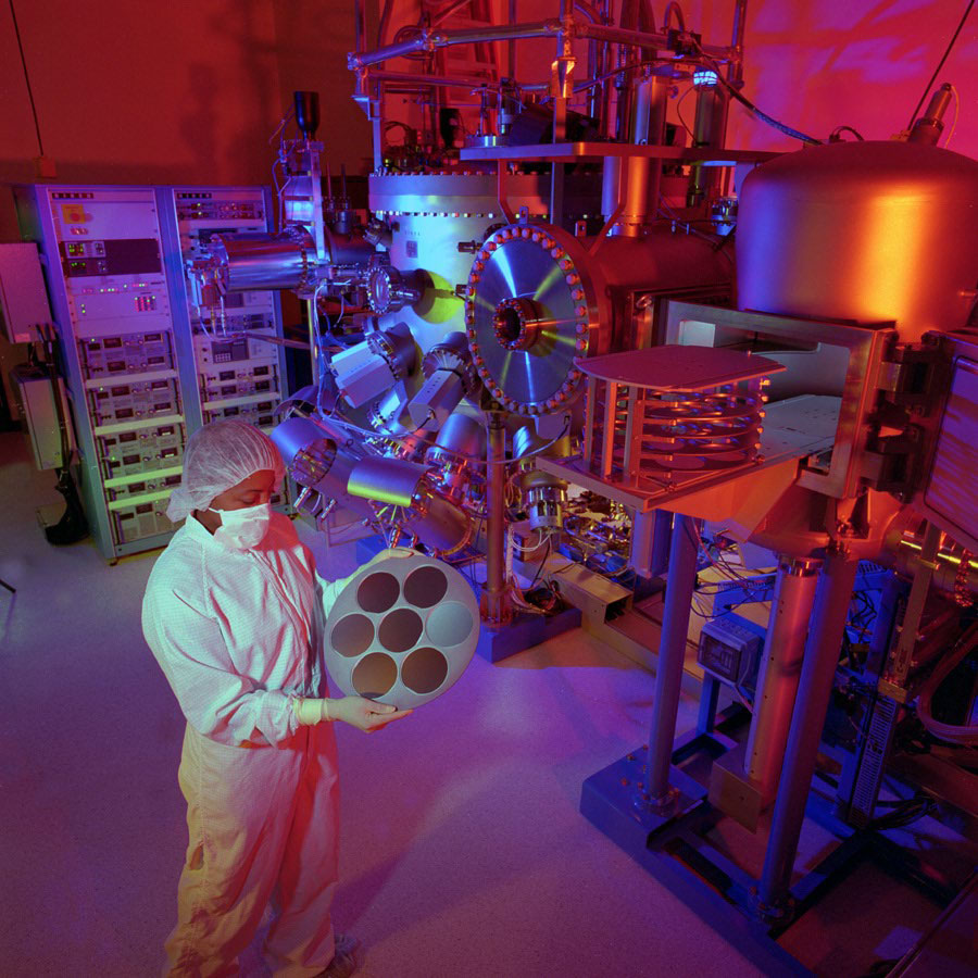 lab technician holding microelectronics component in lab