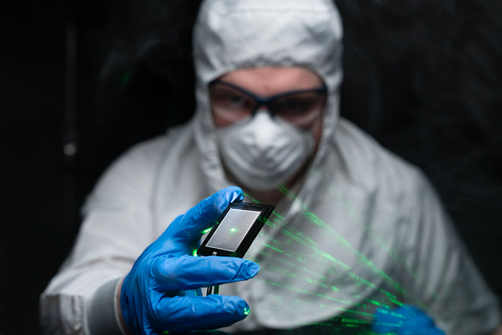 Microelectronics Laser man in cleanroom suit with laser in hand