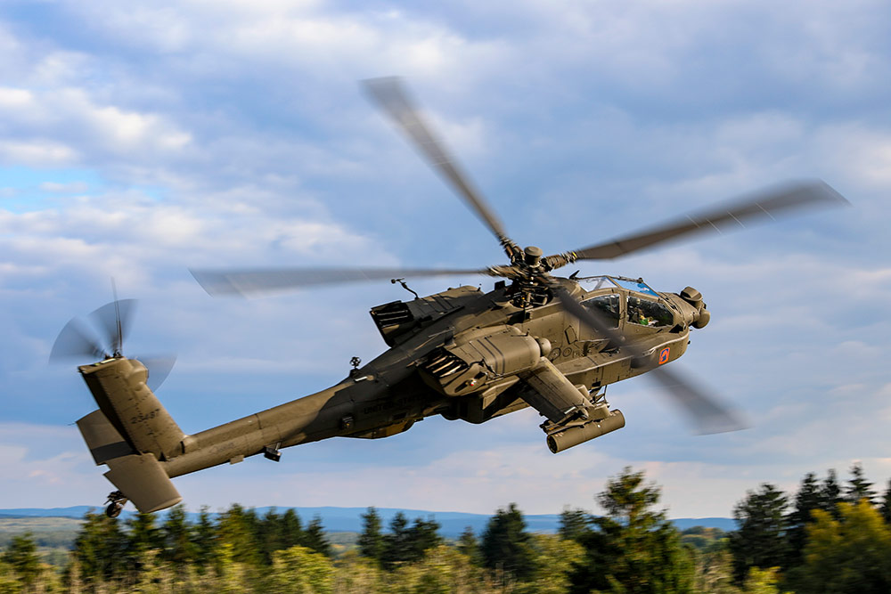 AH-64E apache helicopter flying over trees