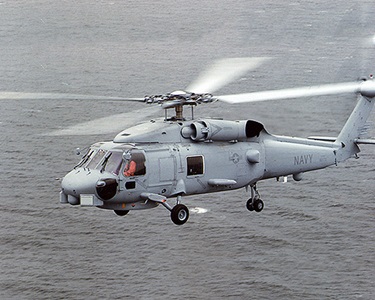 A left side view of an SH-60 Seahawk Light Airborne Multi-purpose System (LAMPS III) helicopter in flight left side view of military helicopter in flight over water