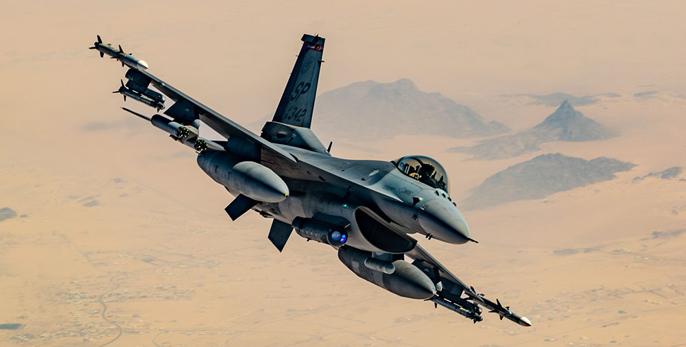 LITENING Advanced Targeting Pod F-16 fighter jet in flight over desert terrain, showcasing military aviation capabilities and technologies.