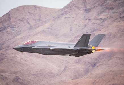 miliary jet flying over mountains