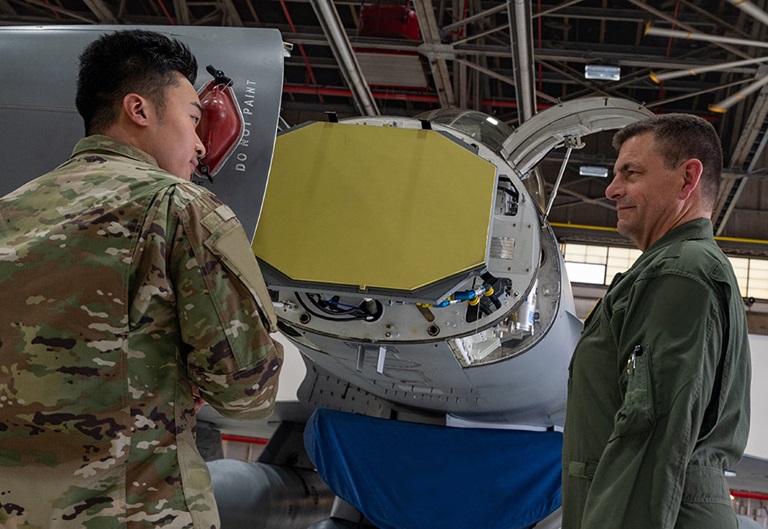 SABR (Scalable Agile Beam Radar) APG-83 AESA two military men standing next to radar installed in aircraft in hanger