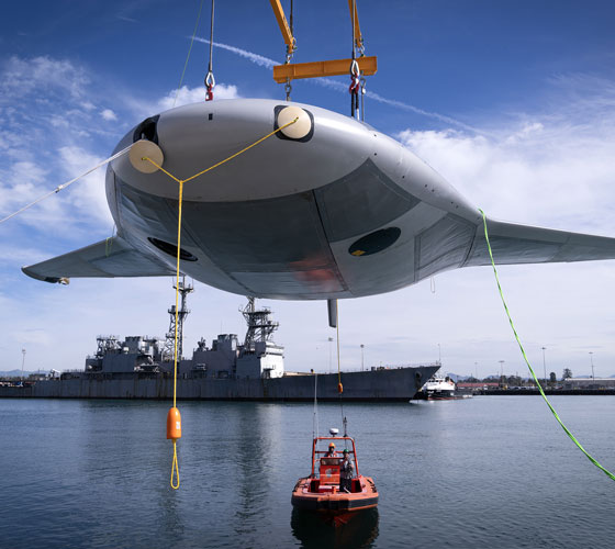Manta Ray vehicle being lowered into the ocean using cranes.