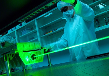man in lab suit working on green laser