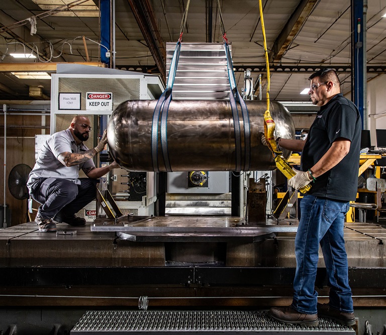 two men working on a propulsion tank