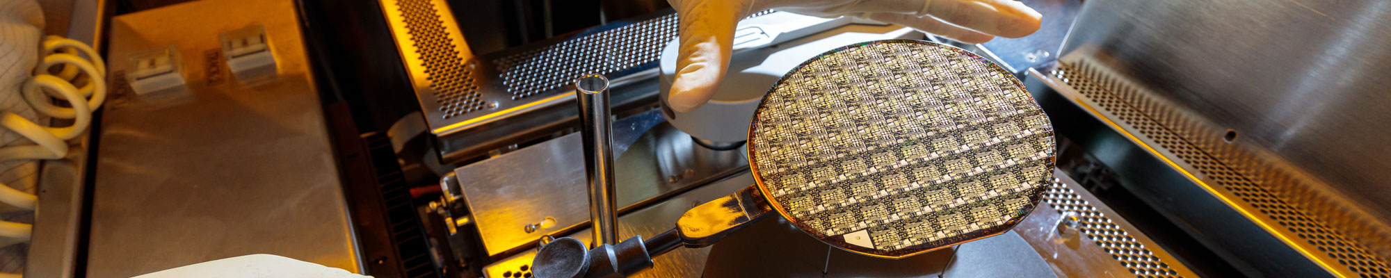 hand reaching for microelectronic component in lab