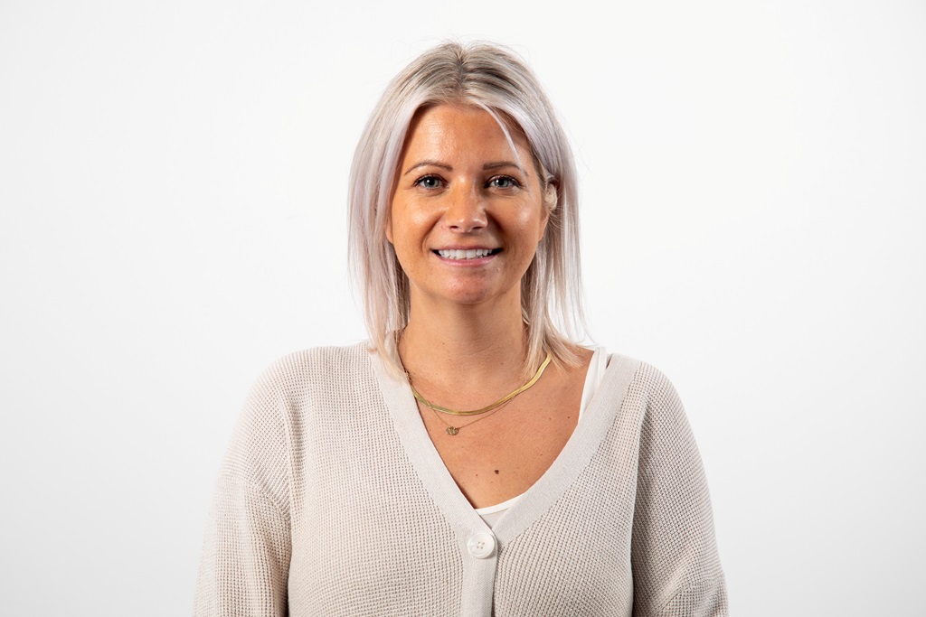 Photo of smiling woman looking at straight ahead. 