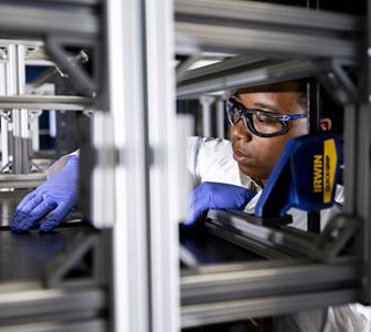 student working on equipment with protective glasses