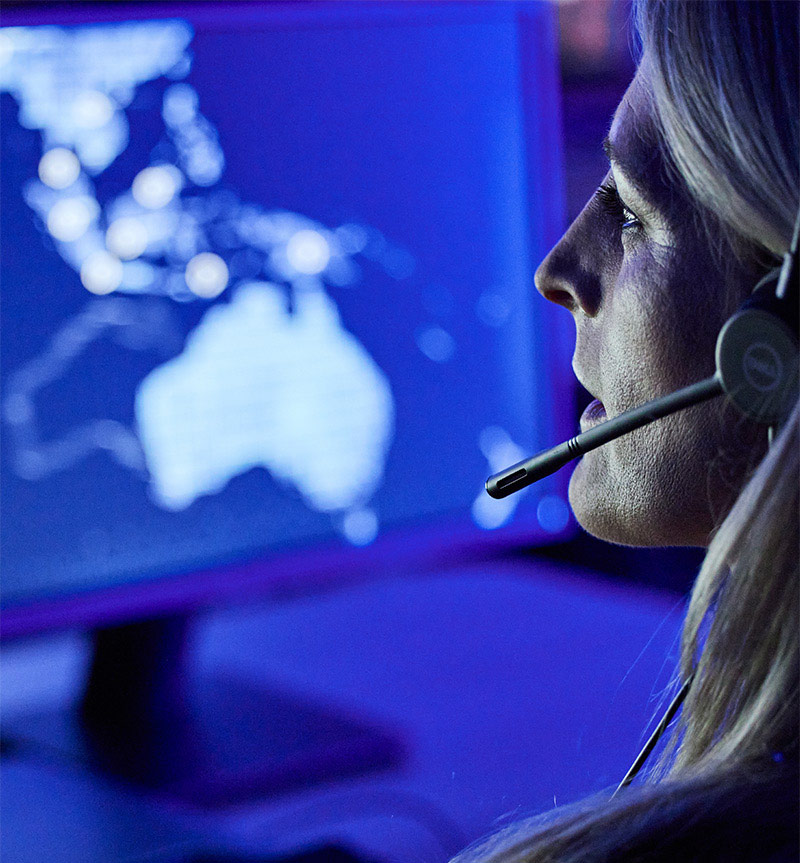 woman with headset in front of computer monitor