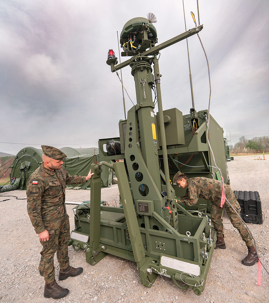 two soliders standing near Integrated Battle Command System