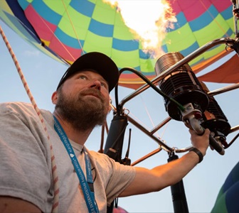 View of man inflating hot air balloon. 