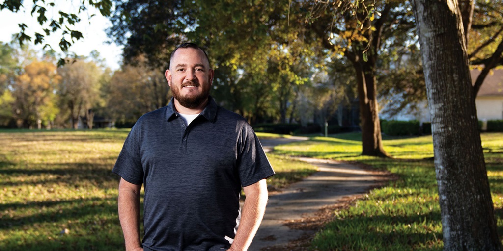 Man standing outside in nature smiling. 